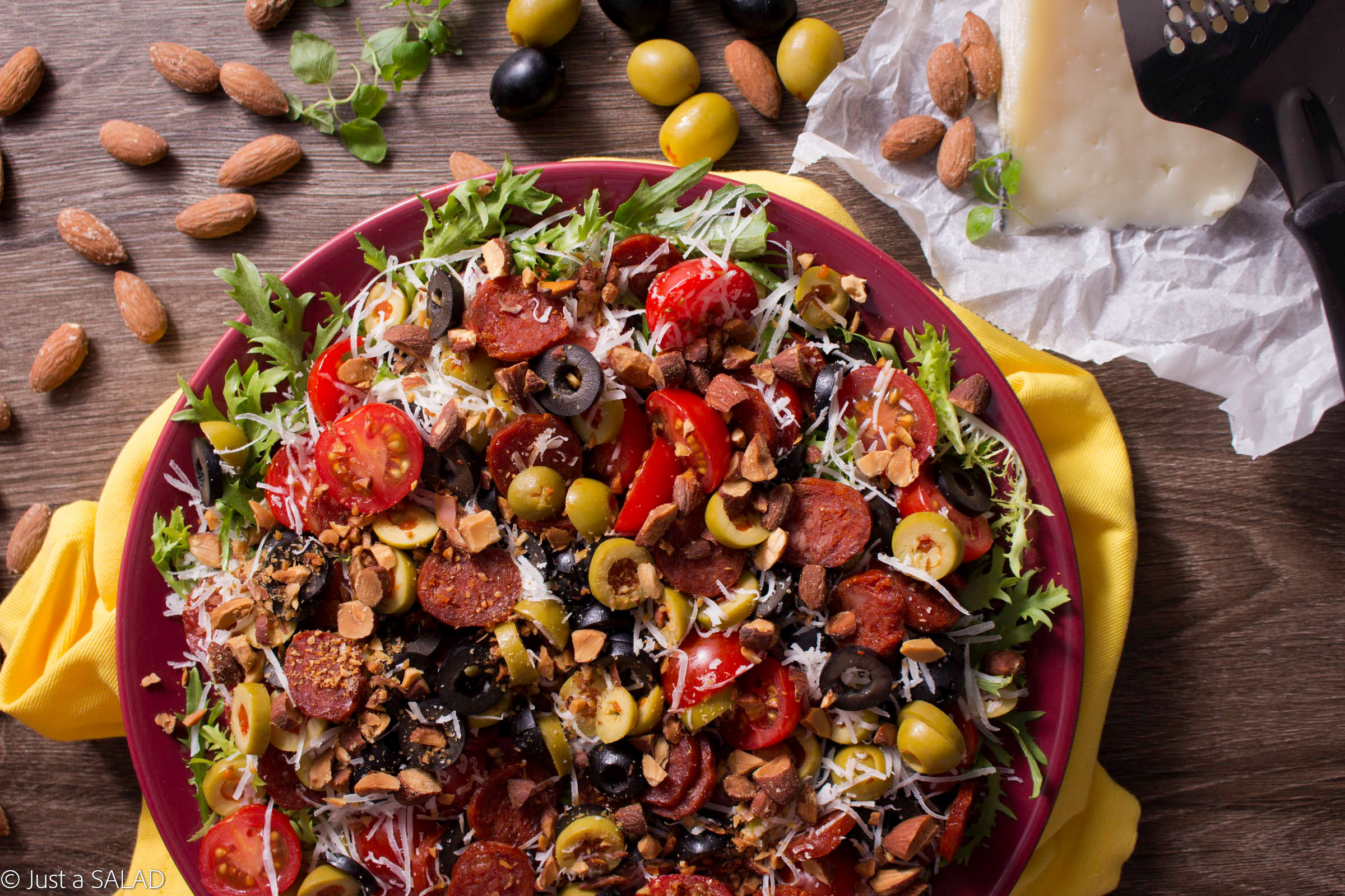 Sałatka z chorizo, owczym serem, oliwkami, pomidorami i migdałami na endywii.