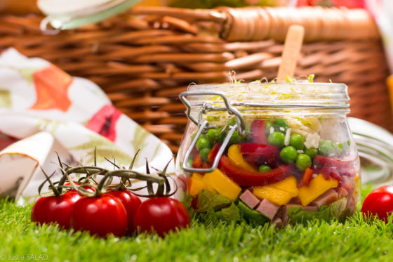 Piknikowy słoiczek. Sałatka piknikowa z kiełbasą krakowską, mango, papryką, groszkiem, serem Grana Padano, kiełkami oraz sosem pomidorowym.