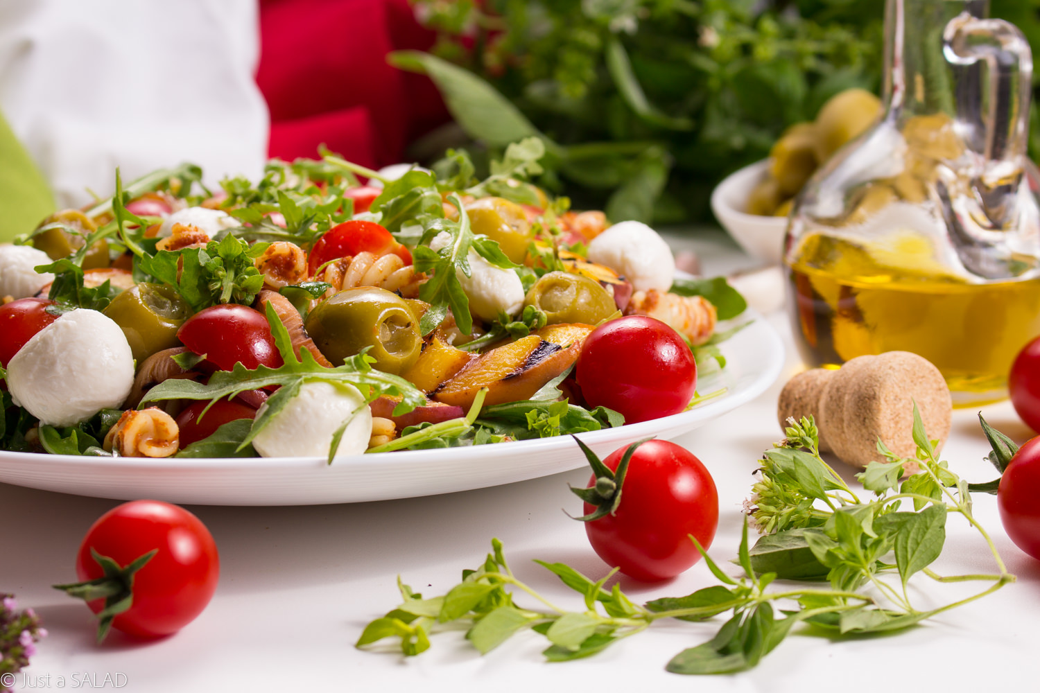 Włoska strona lata. Sałatka z makaronem w pomidorowym pesto, rukolą, pomidorkami, brzoskwiniami, oliwkami i mozzarellą.